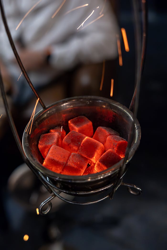 The Art of Drawing Readers In: Your attractive post title goes here Close-up of red hot charcoal cubes emitting sparks in a metal holder.