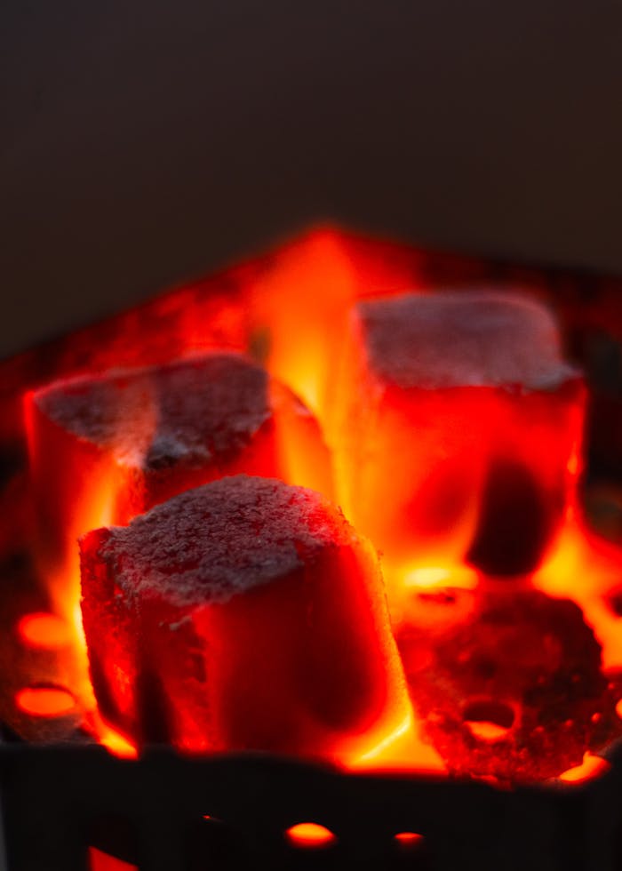 About Intense close-up of red-hot charcoal briquettes, glowing with heat and ready for grilling.